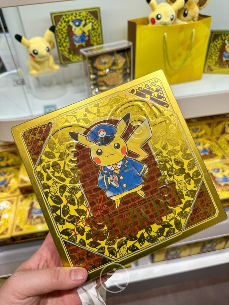 ポケモンストア 東京駅店の駅長ピカチュウをデザインした、ゴールドの缶入りクッキーをクローズアップ。精巧なデザインで、コレクションにもぴったりです。
