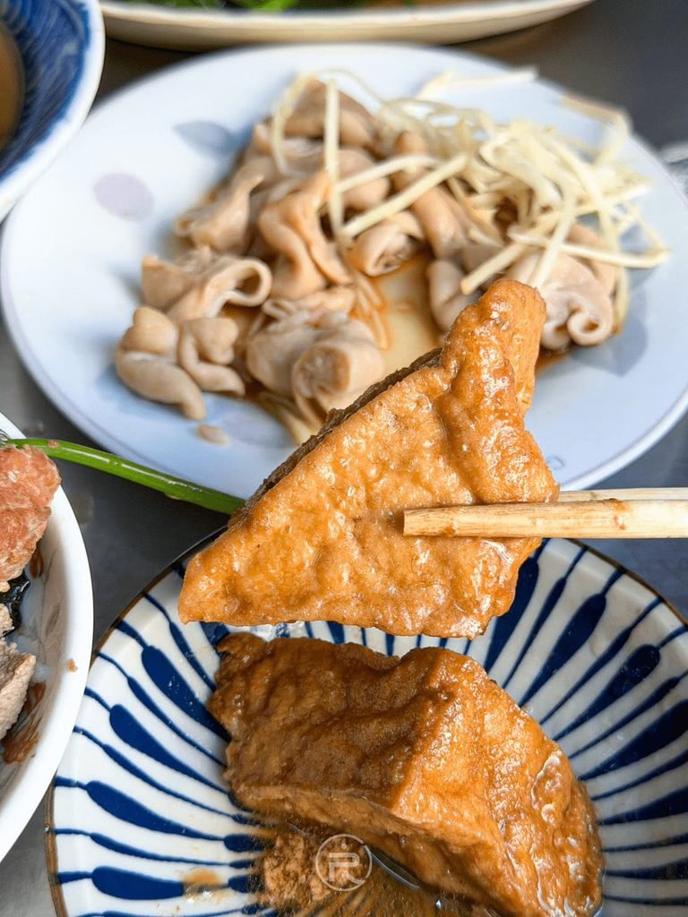 [筷夾整塊油豆腐]： 筷子夾起整塊飽滿多汁的三角油豆腐，豐原在地人狂推必點。
