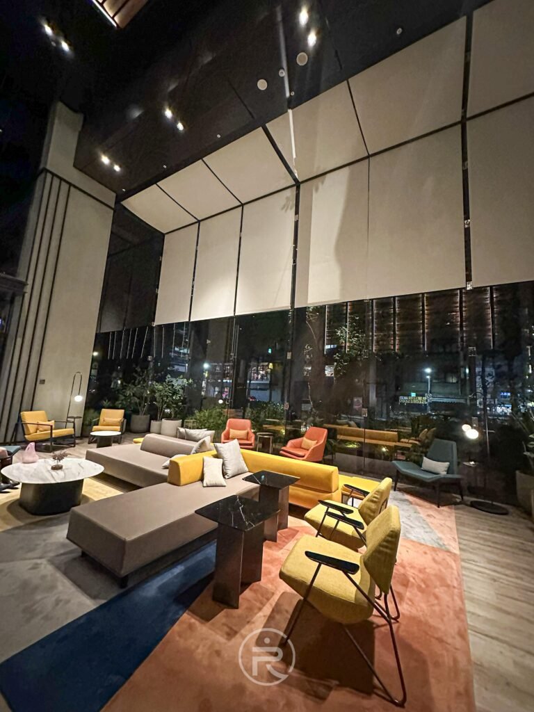 夜色下的大廳內部，燈光灑落呈現低調奢華的電影氛圍。