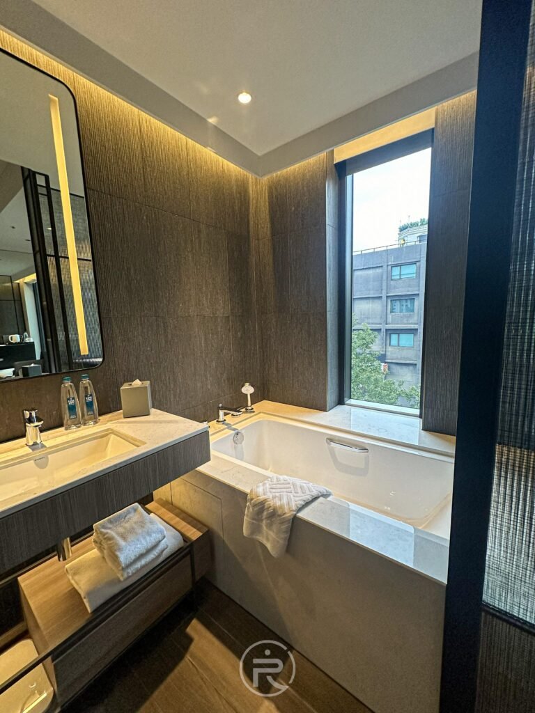浴室內緊鄰窗戶的白色大浴缸，享受邊泡澡邊看市景的愜意。
