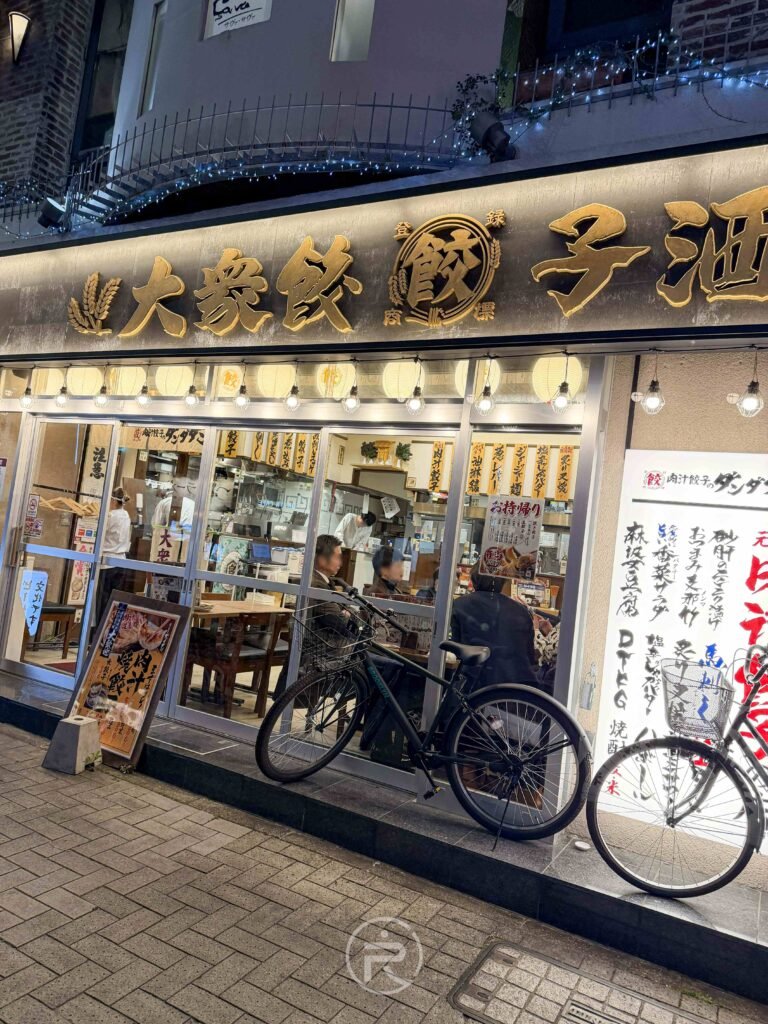 名古屋金山駅前的「肉汁餃子のダンダダン」店面外觀，充滿活力的日式居酒屋裝潢。