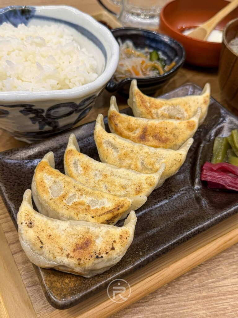 六顆排列整齊的現煎餃子，外皮帶有金黃焦痕，視覺感極其酥脆。