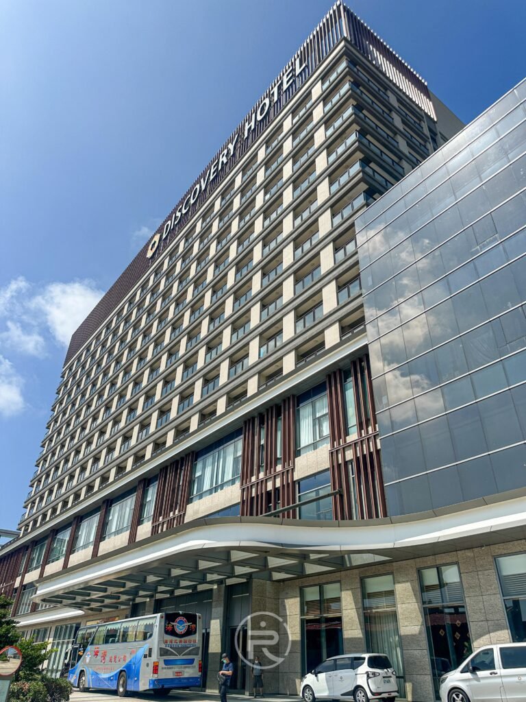 澎澄飯店外觀建築,門口停放澎湖機場與飯店間的免費接駁車。