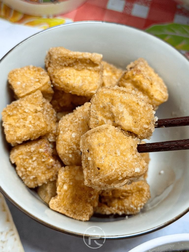 筷子夾起一顆剛起鍋的燙口炸豆腐,呈現完美的蜂巢酥皮。