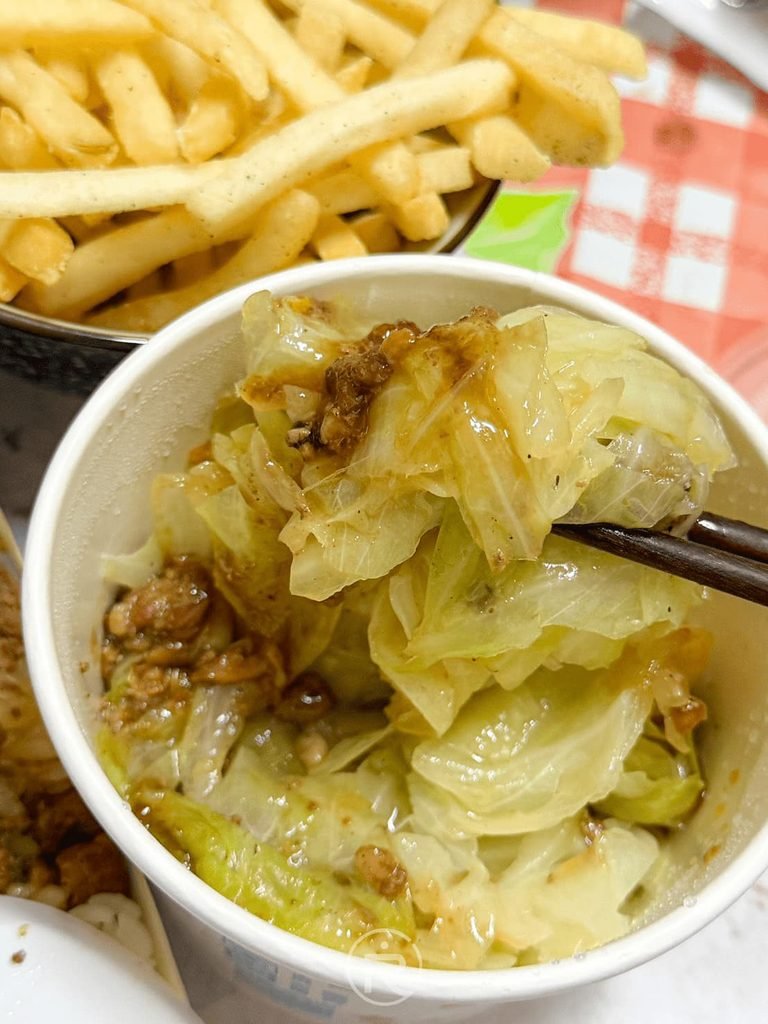 [夾起燙青菜特寫]： 筷子大口夾起鮮甜多汁的肉燥燙高麗菜，爽脆甘甜。