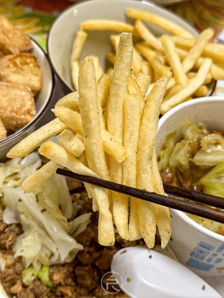 [筷夾現炸薯條]： 筷子夾起金黃長條薯條特寫，外酥內鬆軟的台式下午茶點心。