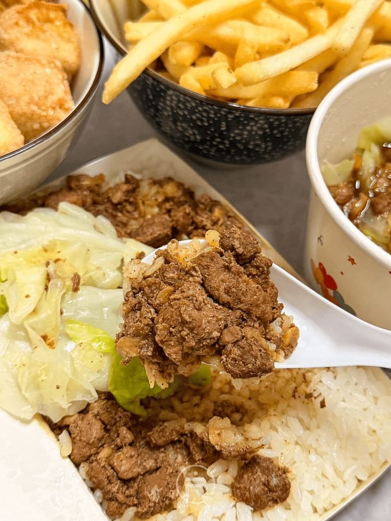 [舀起鹹香肉燥]： 湯匙舀起滿滿肉燥與白飯，鹹香肉汁浸潤米飯非常下飯。