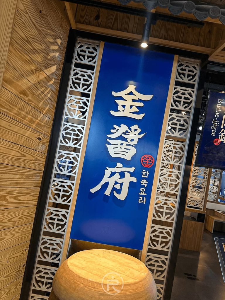 [品牌藍色掛軸]： 店內裝飾的「金醬府 韓式料理」深藍色立體布簾與韓風木質窗櫺。
