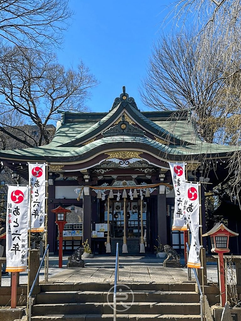  [藍天下的本殿全貌]： 藍天下被蒼翠樹木環抱的川越八幡宮御本殿建築。