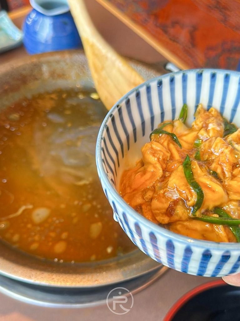 [滑蛋入飯完成]： 剛製作完成的特製滑蛋丼飯（玉子丼）盛於白飯上。