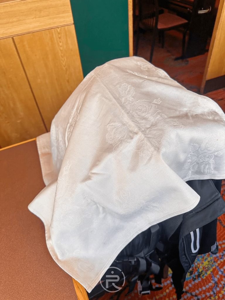 [貼心蓋布]： 店家極致細緻服務：用乾淨白布為客人的後背包防護油煙噴濺。