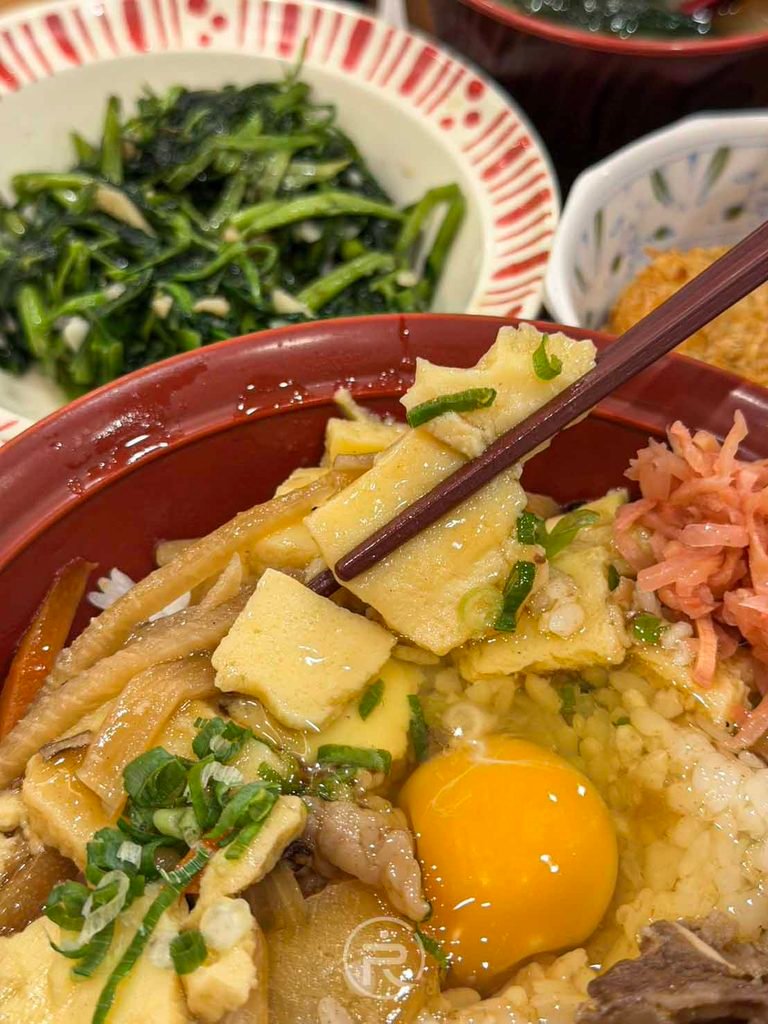 用筷子夾起碗中的日式和風芡汁玉子配料,口感滑潤微甜。