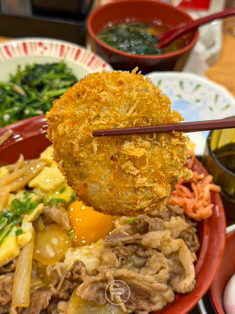 筷子夾起整塊圓滾滾的現炸金黃可樂餅,外皮酥脆感極佳。