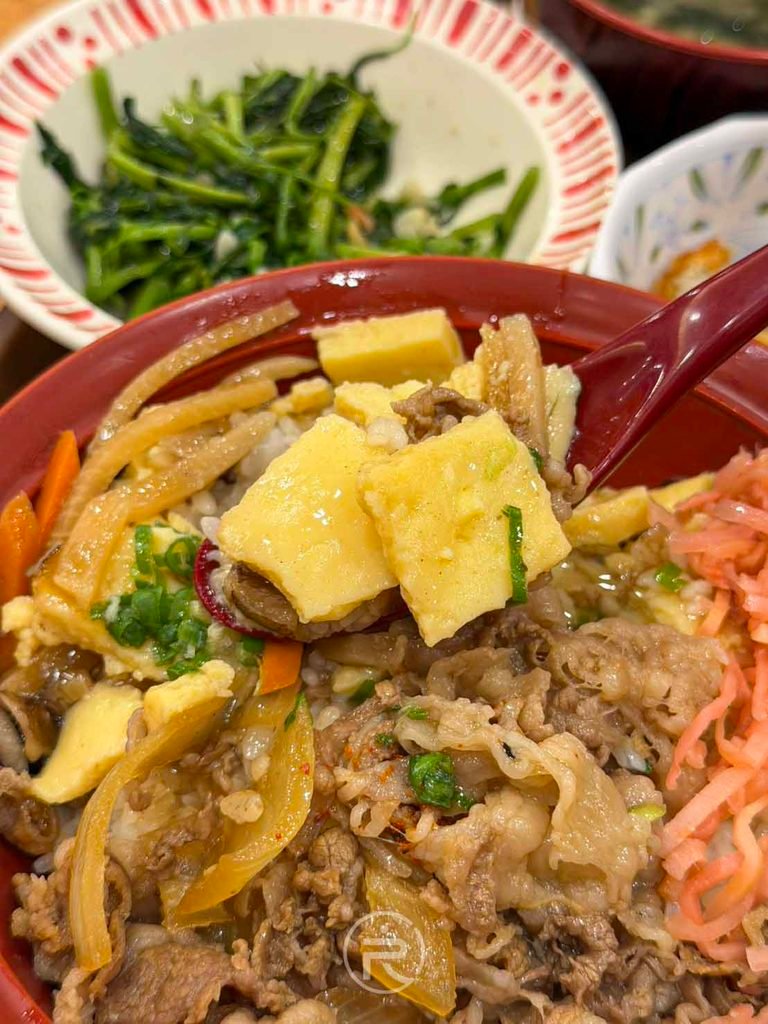 湯匙舀起芡汁玉子塊與吸汁白飯,每一口都溫潤滑順。