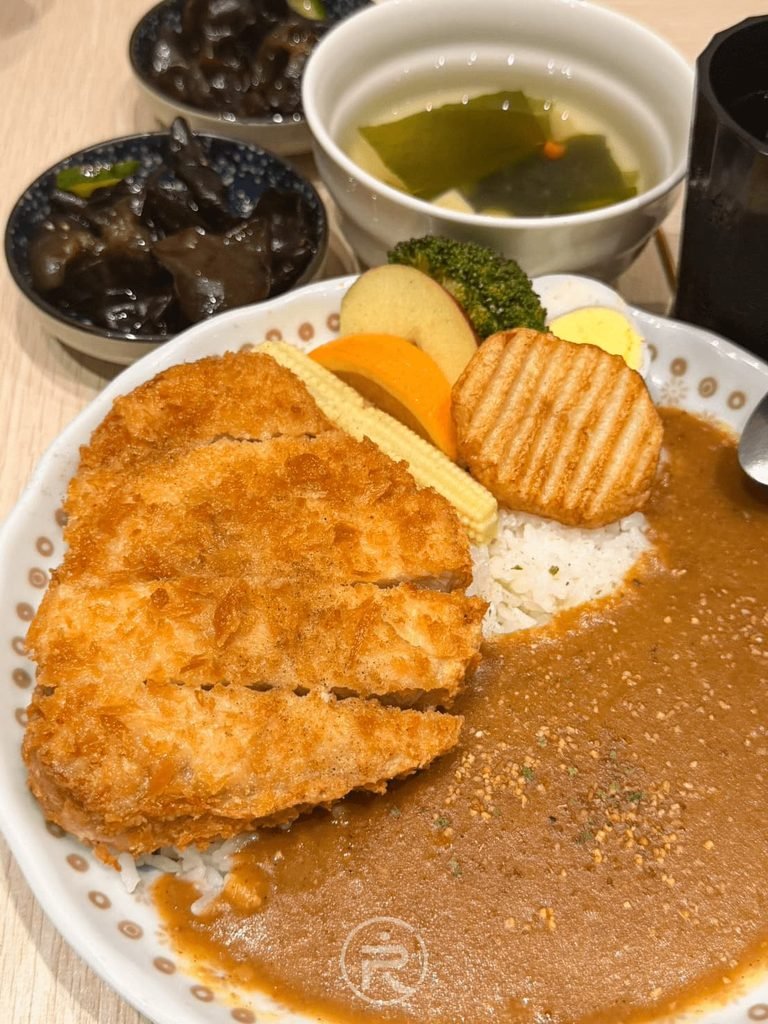  [咖哩拼盤近照]： 炸得金黃微焦的酥脆豬排特寫，份量感十足。
