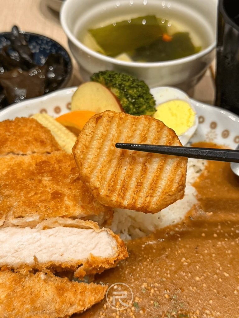  [夾起炸薯格格]： 筷子夾起咖哩盤中的酥脆波浪炸薯片