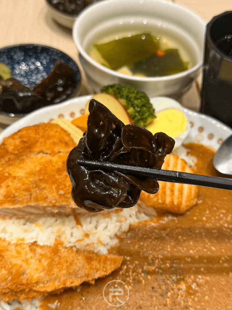 [夾起開胃木耳]： 筷子夾起醃漬入味的爽口黑木耳，解膩效果極佳。