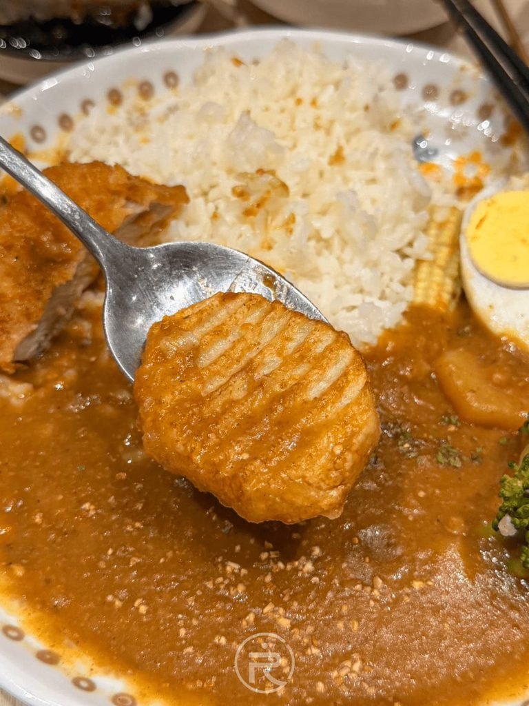  [薯格格沾咖哩]： 湯匙托著吸滿熟成咖哩醬汁的酥脆薯格格，鹹甜香脆。