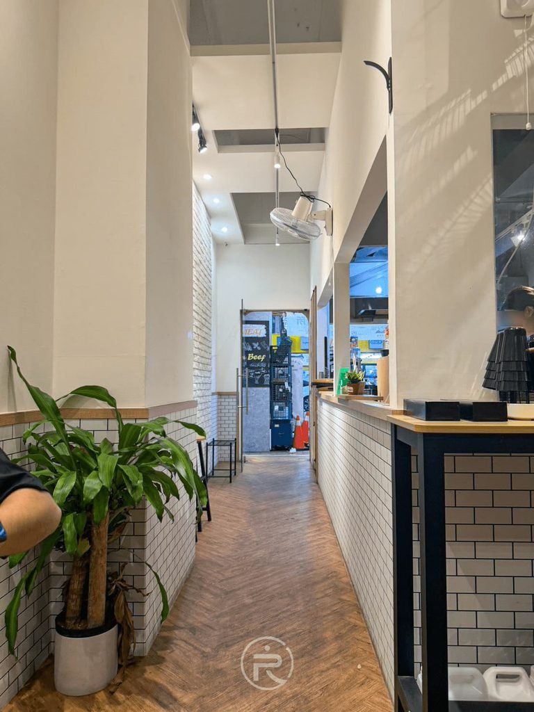 [店內走道空間]： 叁山熟成咖喱所狹長型用餐環境，純白牆面搭配清新綠植栽。
