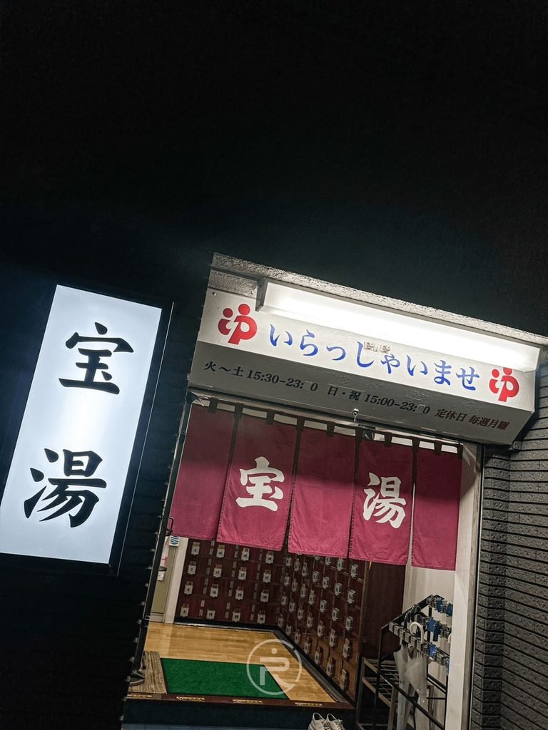 [夜間門面與暖簾]： 東京大田區傳統公共澡堂「宝湯」夜晚入口，掛著印有「宝湯」的紅色暖簾。
