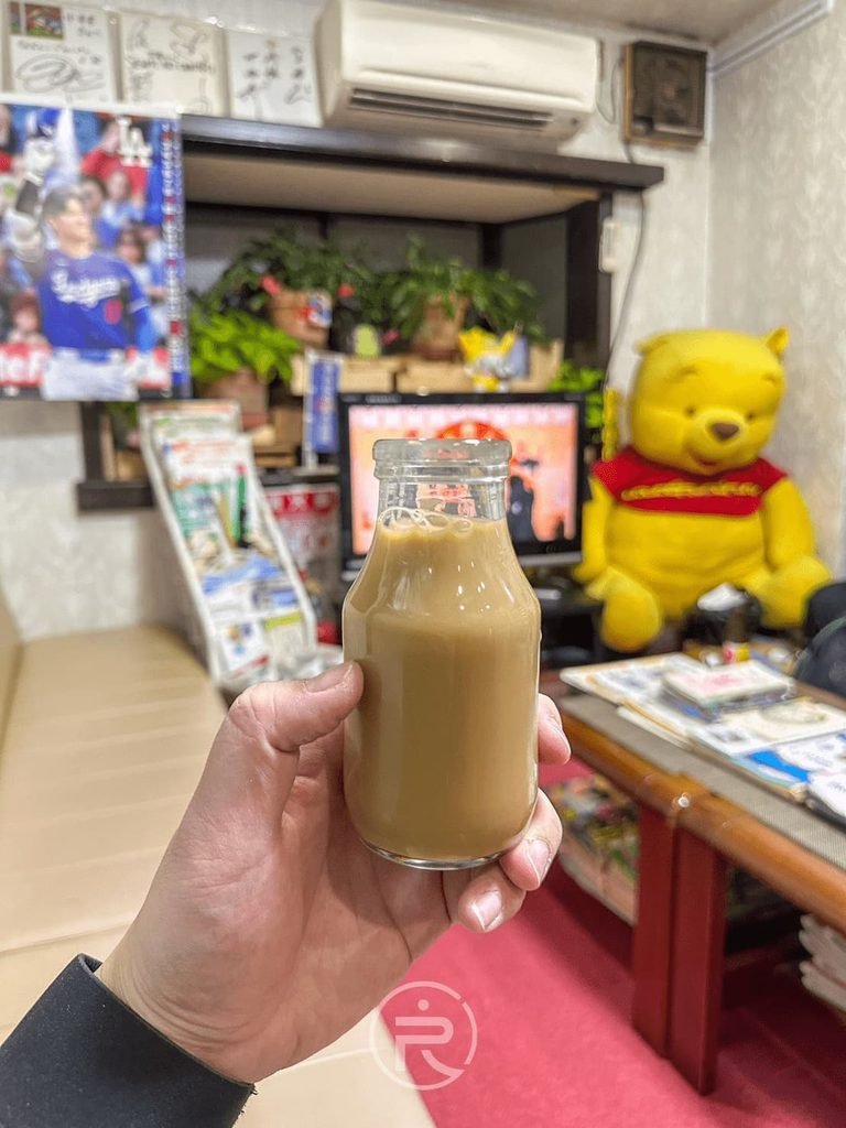 [休息區喝牛奶]： 泡湯後的經典儀式：在復古休息室中手持玻璃瓶裝明治咖啡牛奶。