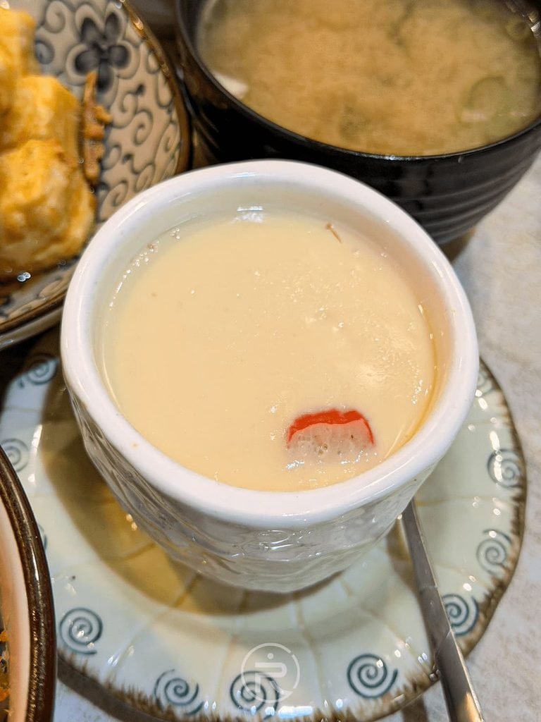  [光滑茶碗蒸表面]： 剛上桌表面如布丁般光滑細緻的日式茶碗蒸，點綴蟳味棒絲。