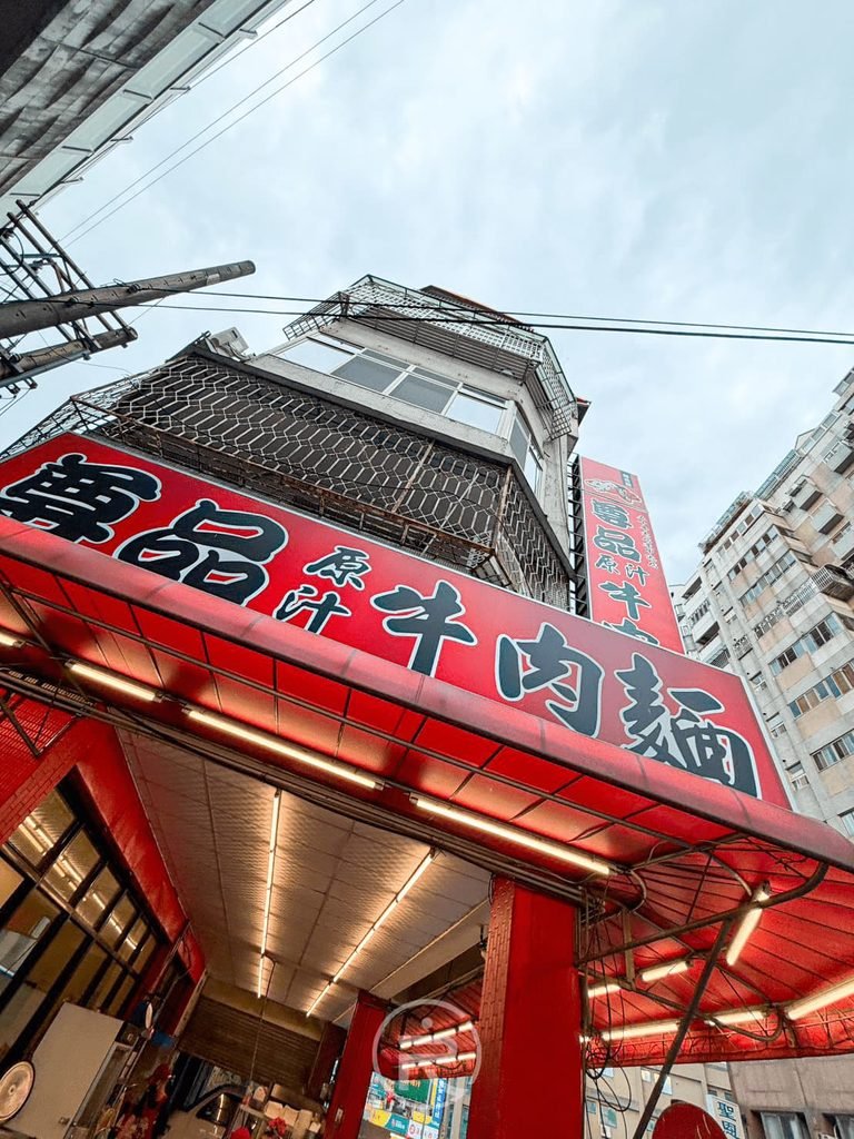  [店面外觀]： 位於台中豐原街角的尊品牛肉麵建築外觀，紅色大招牌醒目氣派。