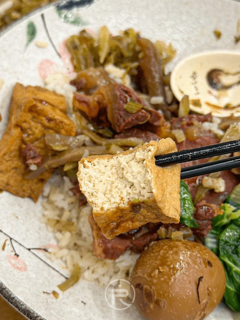  [夾起油豆腐]： 筷子夾起牛三寶飯附贈的厚切油豆腐，吸飽甘醇滷汁。