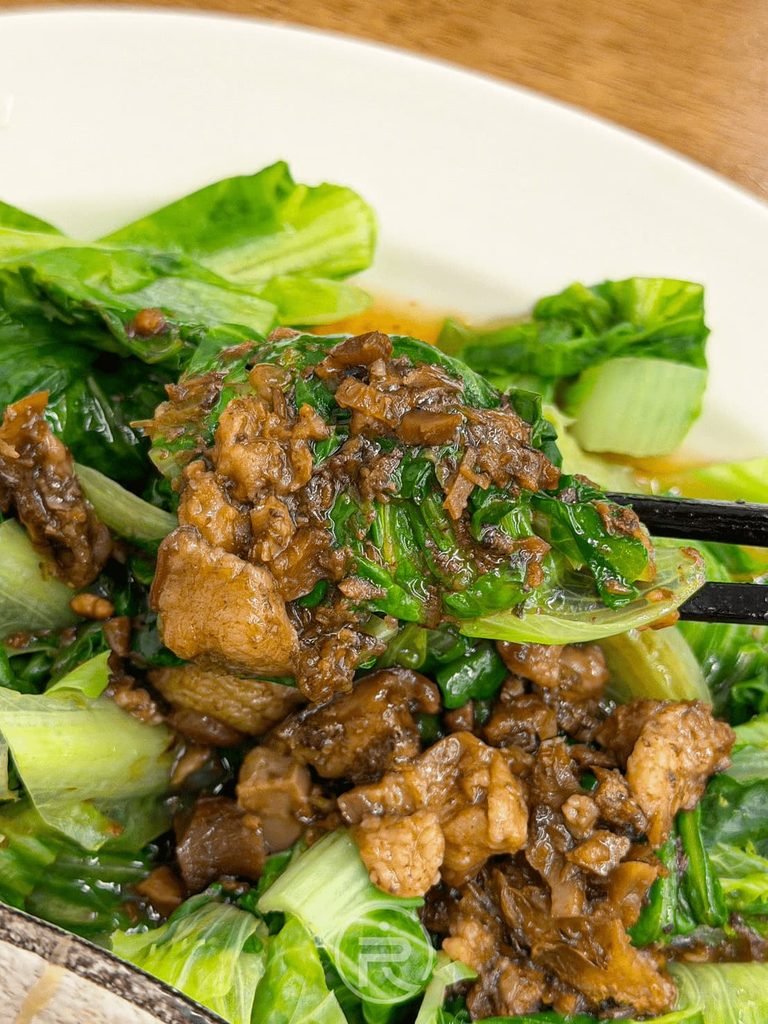  [夾肉燥燙青菜]： 筷子夾起淋滿香濃肉燥的新鮮燙大陸妹青菜。