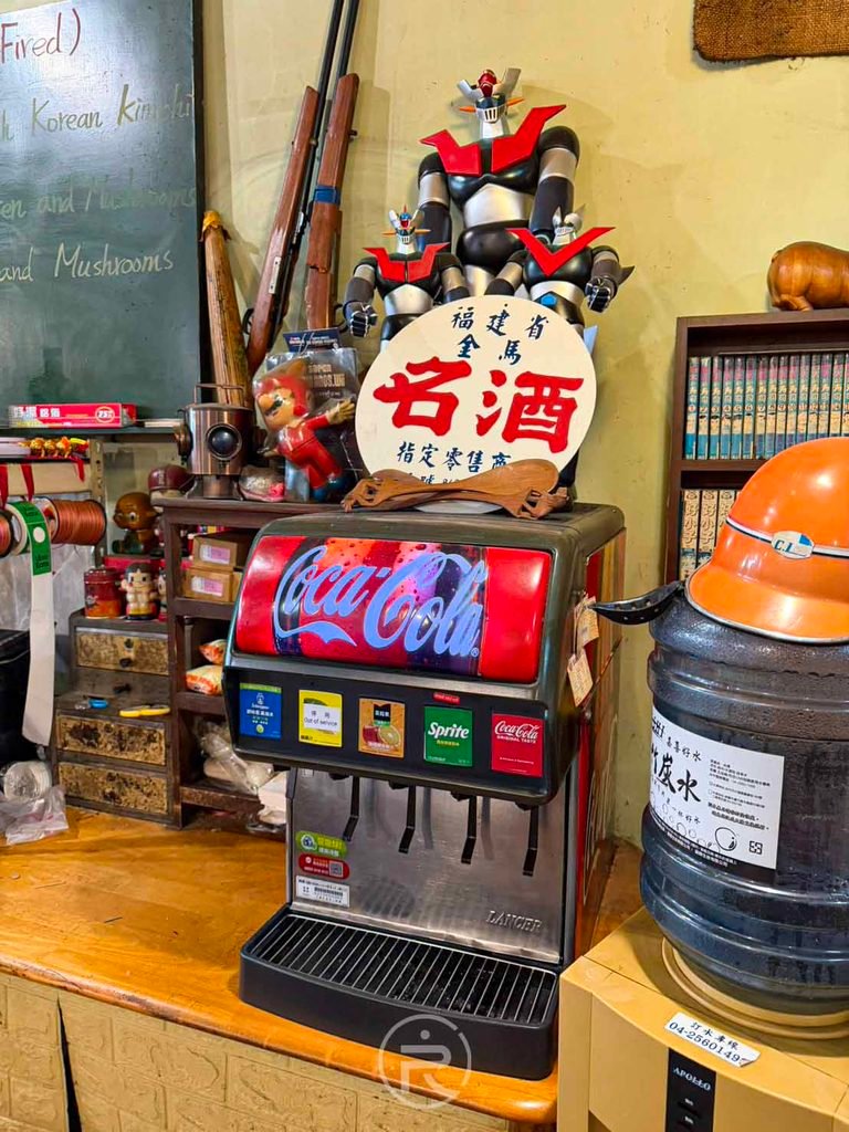  [汽水機與無敵鐵金剛]： 內用免費暢飲的碳酸飲料機，上方陳列經典無敵鐵金剛模型公仔。