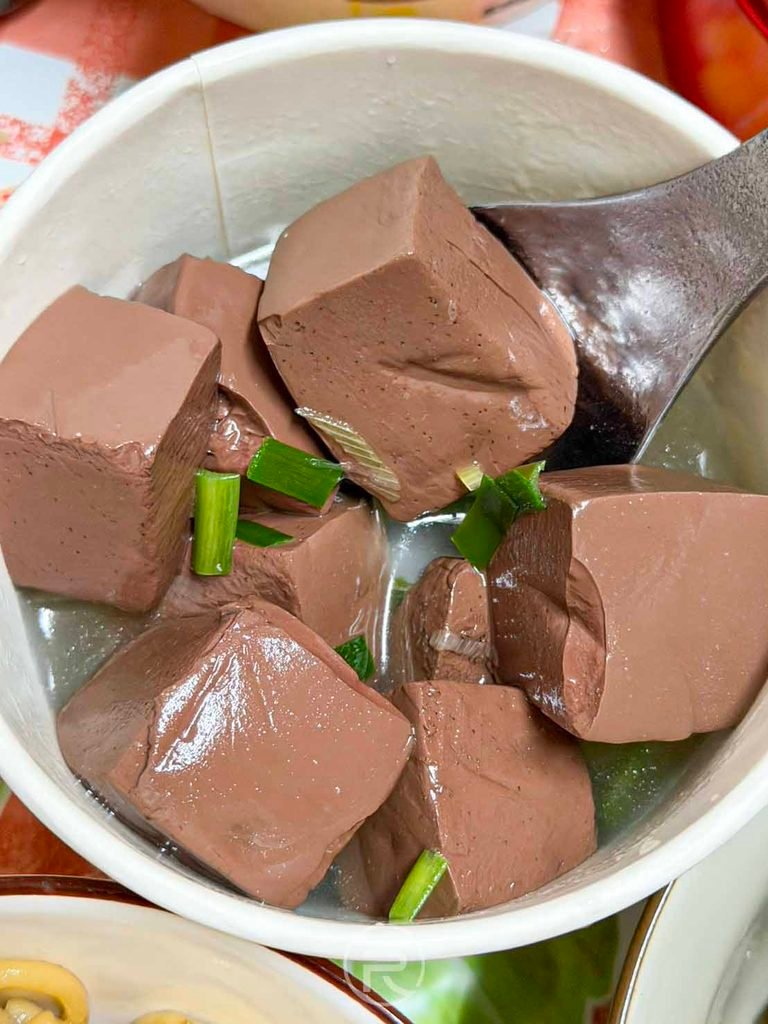 [豬血湯特寫]： 滿滿一大碗新鮮無腥味的厚切豬血塊與清甜大骨韭菜湯底。