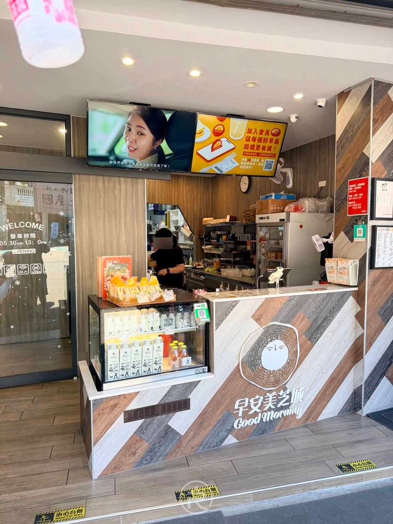 [出餐吧檯]： 豐南概念店乾淨明亮的點餐與出餐櫃台，牆上播放聯名菜單。
