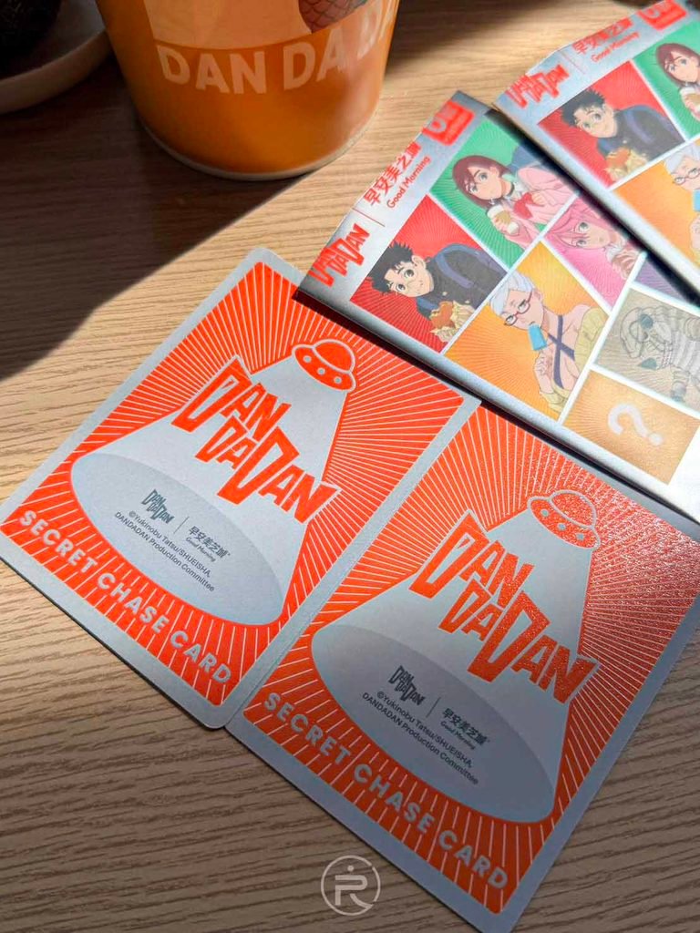 [卡片背面Logo]： 膽大黨卡片背面紅白幾何設計，印有官方 DAN DA DAN 標誌與防偽說明。