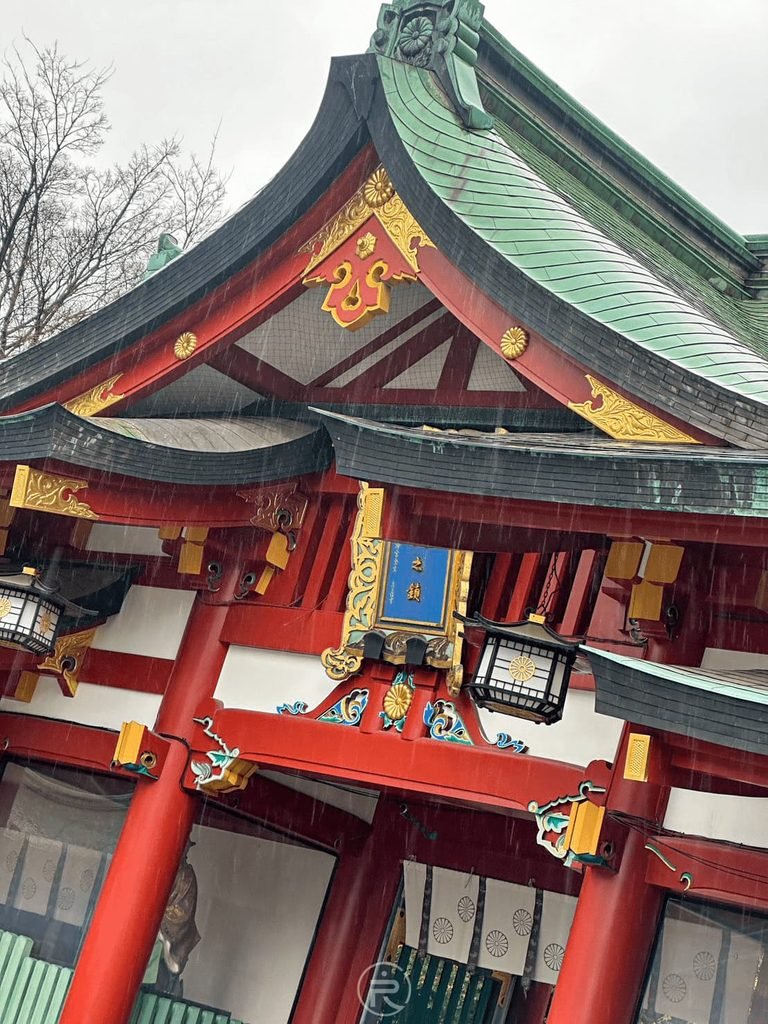 [神門飛簷木雕]： 仰拍日枝神社神門唐破風屋簷，朱紅木柱與綠銅瓦雕花細膩。
