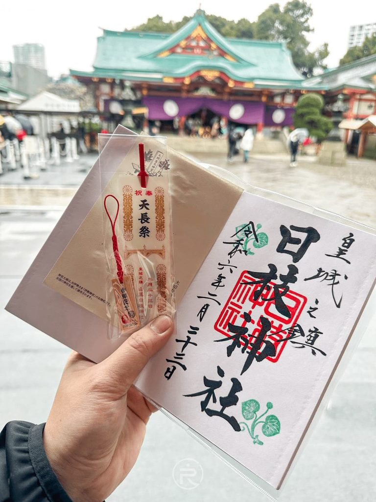 [手持皇城之鎮御朱印]： 手持日枝神社手寫御朱印墨寶，上書「皇城之鎮 日枝神社」與木製書籤合影