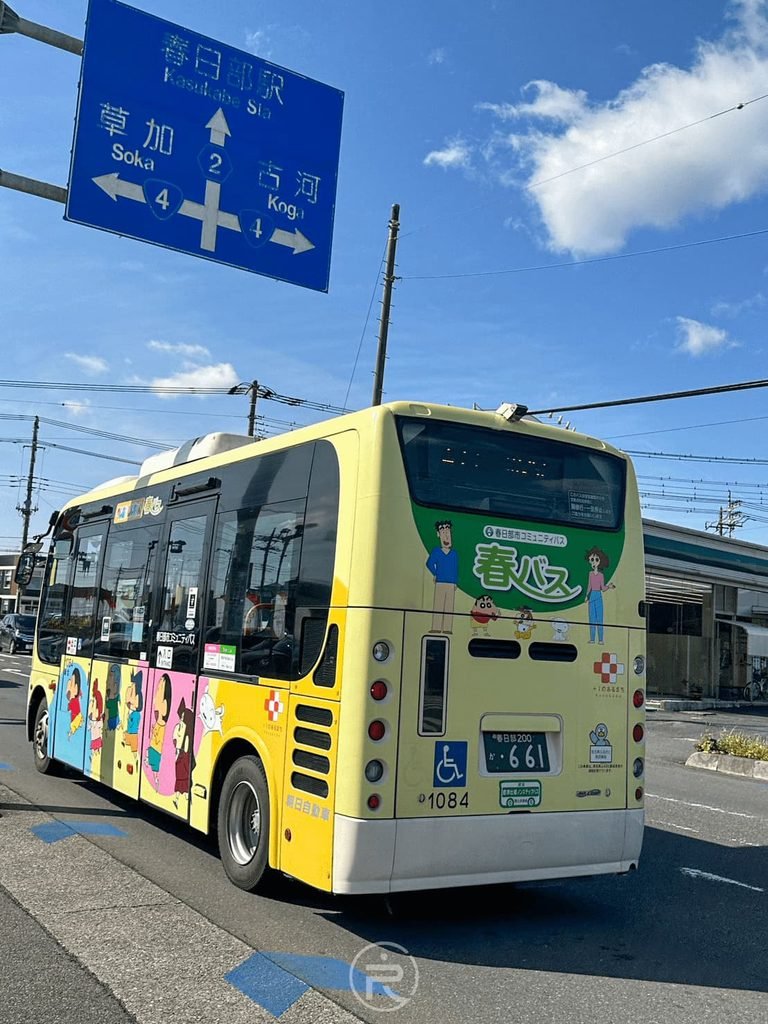 [蠟筆小新春巴士外觀]： 春日部市社區巴士「春巴士（春バス）」，鮮黃色車身彩繪滿滿蠟筆小新插畫。