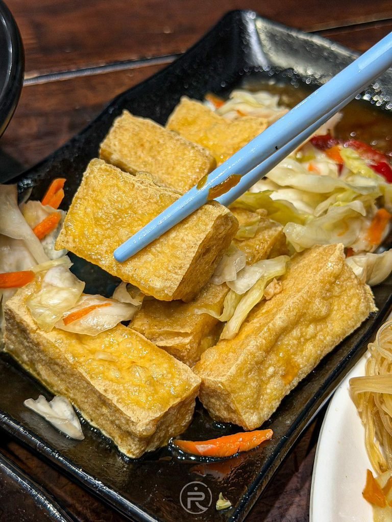  [油豆腐沾醬細節]： 剛炸起鍋金黃酥脆的臭豆腐近照，外皮乾爽不油膩。