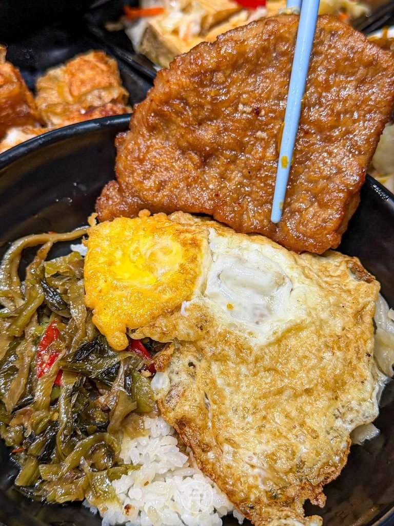  [燒肉荷包蛋全貌]： 招牌燒肉飯特寫，大片燒肉排與荷包蛋蓋滿整碗白飯。