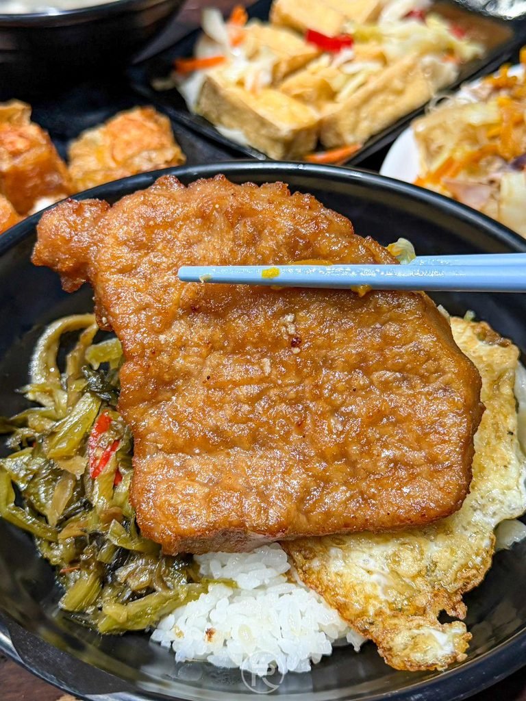 [筷夾燒肉排展示]： 再次夾起沉甸甸的招牌燒肉排，展現澎湖老店豪邁的大份量。