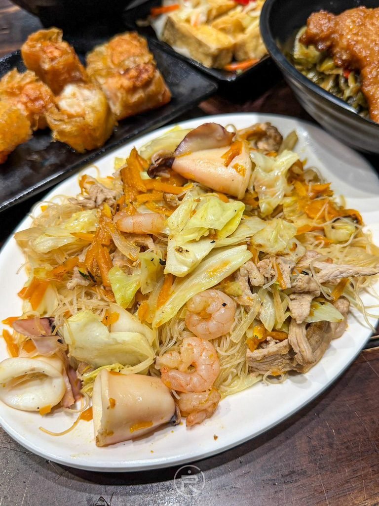[金瓜炒米粉大盤]： 份量驚人的金瓜炒米粉，鋪滿高麗菜、肉絲、鮮蝦仁與澎湖透抽。
