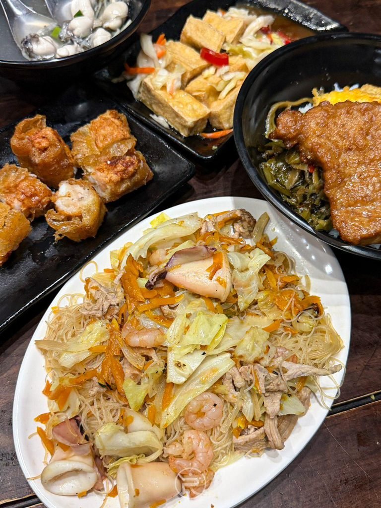 [炒米粉全盤近拍]： 橢圓大盤裝盛的南瓜海鮮炒米粉，色澤金黃誘人。
