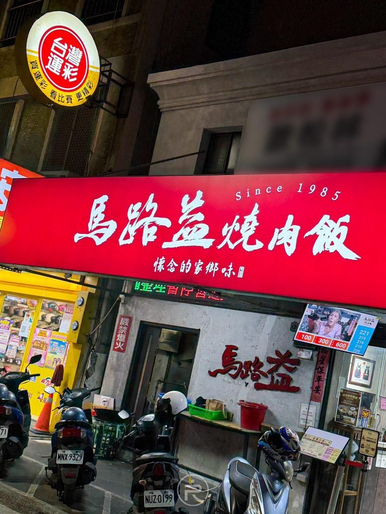 [店面門口夜景全貌]： 位於馬公媽宮城隍廟的馬路益燒肉飯店面，門外停滿機車的熱鬧排隊景象。