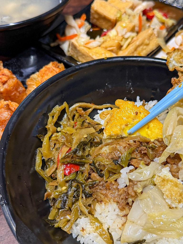 [肉燥酸菜白飯底]： 燒肉飯碗底特寫，淋上甘醇肉燥滷汁並鋪上古早味酸菜。