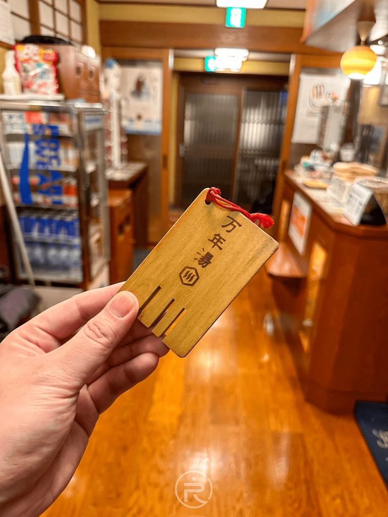[木牌背面萬年湯字樣]： 木牌鑰匙正面刻有「萬年湯」專屬字樣，極具收藏與體驗感。
