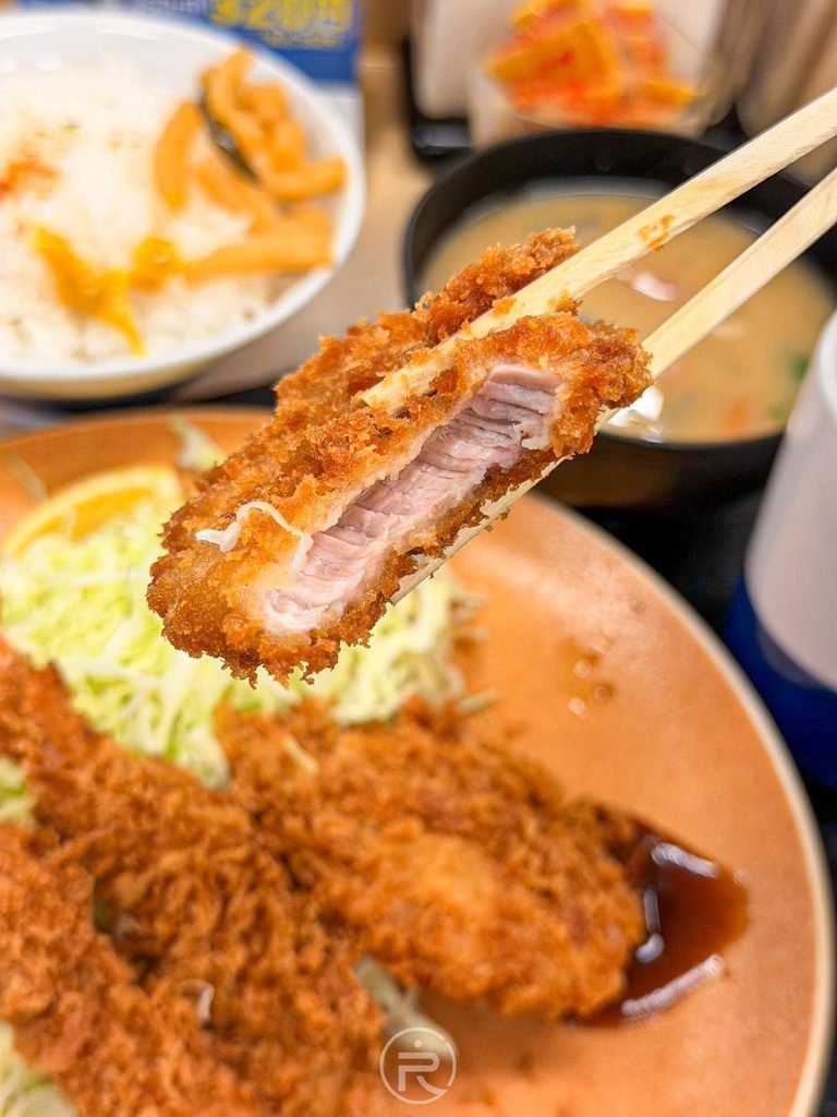  [腰內肉粉嫩斷面]： 咬開豬排展現內部厚實軟嫩、毫無乾澀感的粉白色豬腰內肉斷面。