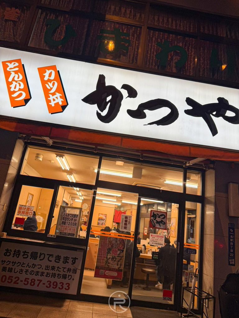  [夜間店面正門]： 夜色下燈火通明的吉豚屋名古屋名駅店玻璃大門與紅色招牌外觀。