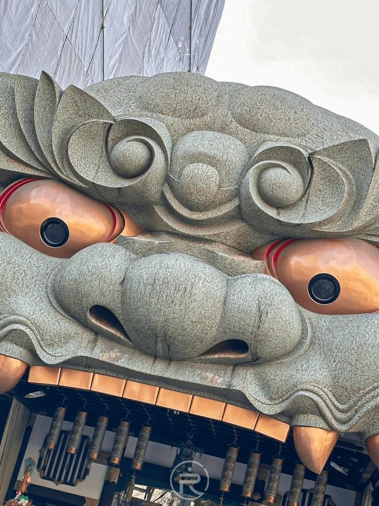 [獅子頭面部特寫]： 獅子殿青銅銅鈴大眼與銳利獠牙的近距離震撼特寫。
