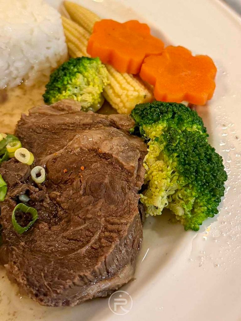  [厚切牛胸肉近拍]： 燉煮至極其軟嫩的牛胸肉特寫，撒上新鮮青蔥花點綴，肉質紋理清晰。