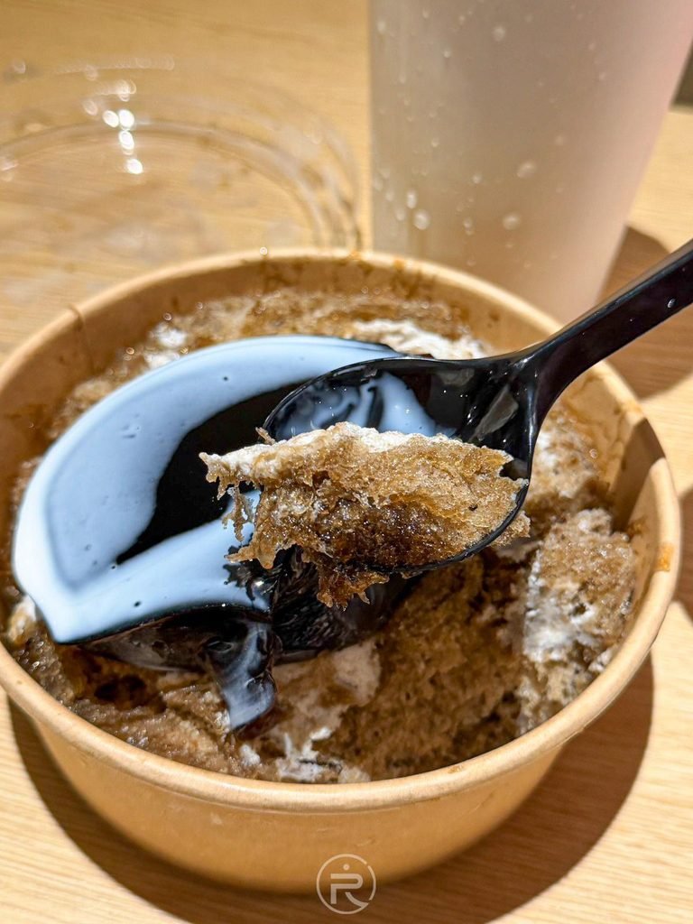 [舀起仙草凍與冰絲]： 湯匙同時舀起 Q 彈仙草凍與帶有纖維感的仙草絲刨冰。