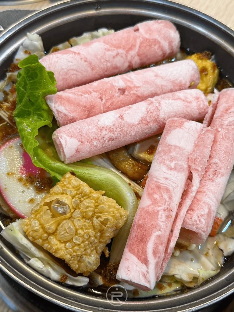 [沙茶鍋生食近照]： 剛上桌的汕頭沙茶豬肉鍋生食，鋪滿新鮮豬肉片、青菜與豆皮。